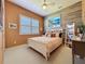 Bright bedroom with wood-look accent wall, plantation shutters, and comfortable bed at 250 Bayou Bend Rd, Groveland, FL 34736