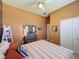 Spacious bedroom with a dresser, mirror, and striped bedding at 250 Bayou Bend Rd, Groveland, FL 34736