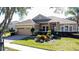 Single-story home with a beige facade, attached garage, and well-manicured landscaping at 250 Bayou Bend Rd, Groveland, FL 34736