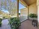 Front porch with brick pavers, white railing, and lush landscaping at 250 Bayou Bend Rd, Groveland, FL 34736