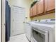 Convenient laundry room with washer, dryer, and cabinets at 250 Bayou Bend Rd, Groveland, FL 34736