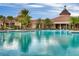 Resort-style pool with palm trees and a clubhouse in the background at 250 Bayou Bend Rd, Groveland, FL 34736