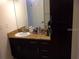 Bathroom with granite vanity, dark wood cabinets and a mirror at 2558 Robert Trent Jones Dr # 1427, Orlando, FL 32835