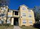 Two-story condo building with multiple units, landscaping, and parking at 2558 Robert Trent Jones Dr # 1427, Orlando, FL 32835
