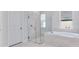 Bright bathroom featuring a glass shower, soaking tub, and marble tile throughout the space at 2987 Arranmore Dr, Ormond Beach, FL 32174