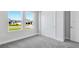 Sunlit bedroom featuring gray carpet, two windows with pleasant outdoor views, and a closet at 2987 Arranmore Dr, Ormond Beach, FL 32174