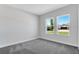 Bright bedroom with gray carpet and two windows offering plenty of natural light and outdoor views at 2987 Arranmore Dr, Ormond Beach, FL 32174