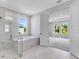 Modern bathroom featuring a glass-enclosed shower, soaking tub, and doorway to the carpeted main bedroom at 2987 Arranmore Dr, Ormond Beach, FL 32174