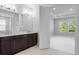 Stylish bathroom featuring double vanity, dark wood cabinetry, and a doorway to the bedroom at 2995 Arranmore Dr, Ormond Beach, FL 32174