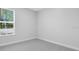 Light filled bedroom featuring gray carpet, white walls and window with blinds at 2995 Arranmore Dr, Ormond Beach, FL 32174