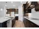 Modern kitchen with white countertops, dark wood cabinetry, and stainless steel appliances at 2995 Arranmore Dr, Ormond Beach, FL 32174