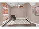 Cozy bedroom features a neutral color palette, ceiling fan, and a large window for natural light at 3401 Abalone Blvd, Orlando, FL 32833
