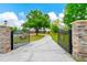 Ornate black metal gate opens to a long driveway leading to a home at 3401 Abalone Blvd, Orlando, FL 32833