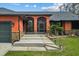 Front entrance of an orange home with stone accents and a screened porch at 3401 Abalone Blvd, Orlando, FL 32833