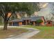 Orange home with three-car garage, curved driveway, and landscaped yard at 3401 Abalone Blvd, Orlando, FL 32833