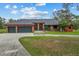 Beautiful orange home with a three-car garage and a large front yard at 3401 Abalone Blvd, Orlando, FL 32833