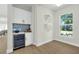Stylish home bar area featuring a modern wine cooler, white cabinets, and natural light at 500 W Hazel St, Orlando, FL 32804