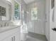 Modern bathroom with subway tile shower, glass door, white vanity, and window with natural light at 500 W Hazel St, Orlando, FL 32804