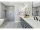 Bright bathroom features gray cabinets, quartz countertops, modern fixtures, soaking tub and walk-in shower at 500 W Hazel St, Orlando, FL 32804