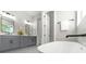 This bathroom features a soaking tub, double vanity with gray cabinets and a view of the landscaped yard at 500 W Hazel St, Orlando, FL 32804