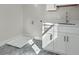 Well-lit laundry room featuring patterned tile flooring, white cabinets, quartz countertops, and modern fixtures at 500 W Hazel St, Orlando, FL 32804