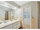 Bright bathroom featuring double sinks and access to a hallway at 5032 River Lake Rd, Winter Haven, FL 33884