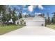 Single story house with a three-car garage and lush green lawn at 606 Urick St, Fruitland Park, FL 34731