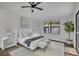 A well-lit bedroom with white decor, a ceiling fan, and dark wood-look floors at 67 Sabal Cay Court, New Smyrna Beach, FL 32169