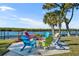 Inviting fire pit area with colorful chairs overlooking the water at 67 Sabal Cay Court, New Smyrna Beach, FL 32169