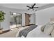 Modern main bedroom with access to the outdoors, a ceiling fan, and dark wood-look floors at 67 Sabal Cay Court, New Smyrna Beach, FL 32169
