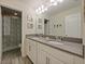 Bathroom with double sinks, a large mirror, and a shower at 7043 Oxbow Rd, Minneola, FL 34715