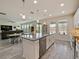 Open kitchen with large island, white cabinets and stainless steel appliances at 7043 Oxbow Rd, Minneola, FL 34715