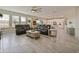 Open living room featuring leather couches, a coffee table, and a view into the kitchen at 7043 Oxbow Rd, Minneola, FL 34715