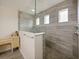 Walk-in shower with glass enclosure and gray tile walls at 7043 Oxbow Rd, Minneola, FL 34715