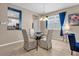 Dining area with glass table and beige chairs, view into kitchen at 8060 Bowery Dr, Winter Garden, FL 34787
