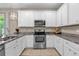 Bright kitchen with white cabinets, granite countertops, and stainless steel appliances at 8060 Bowery Dr, Winter Garden, FL 34787
