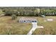 Aerial view of a single-story house with a large yard, detached shed, and paved driveway at 851 Marllo Rd, Kissimmee, FL 34744