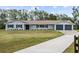 Newly renovated home with gray exterior, two-car garage, and a long driveway at 851 Marllo Rd, Kissimmee, FL 34744