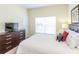 Bedroom with queen bed, dresser, and window at 8956 California Palm Rd, Kissimmee, FL 34747