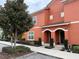 Orange two-story building with two entrances and landscaping at 8956 California Palm Rd, Kissimmee, FL 34747