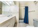 Clean bathroom with a white vanity and a shower with blue curtain at 1115 Lake Nettie Dr Dr, Eustis, FL 32726