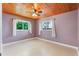 Bedroom with wood ceilings, two windows, and light purple walls at 1115 Lake Nettie Dr Dr, Eustis, FL 32726