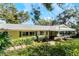 House exterior showcasing a large covered patio and lush greenery at 1115 Lake Nettie Dr Dr, Eustis, FL 32726