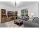 Cozy living room with gray sofa, ottoman, and built-in entertainment center at 1134 Kingsbarn St, Davenport, FL 33896