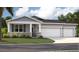 Charming single-story home features a stone facade, blue shutters, and a three-car garage at 12795 Trovita Dr, Grand Island, FL 32735
