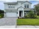 Two-story house with gray siding, white garage door, and landscaped lawn at 1445 Olympic Club Blvd, Champions Gate, FL 33896