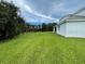 Side view of the house showing a large backyard and surrounding landscape at 1445 Olympic Club Blvd, Champions Gate, FL 33896