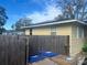 Home's rear elevation, showing wooden fence and utilities at 1606 Lime St, Kissimmee, FL 34746