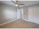 Bright bedroom with ceiling fan, wood-look tile floors, and double-door closet at 2419 Rio Pinar Lakes Blvd, Orlando, FL 32822