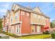 Two-story townhome with orange and tan siding, landscaping, and a paved walkway at 2634 Sunrise Shores Dr, Kissimmee, FL 34747